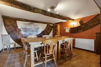 a dining room with a wooden table and chairs at The Coppermines Mountain Cottages - Sawyers, Carpenters, Millrace, Sleeps 18 in Coniston