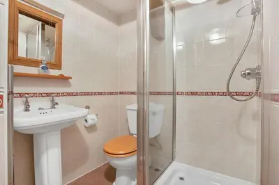 a bathroom with a toilet and a sink and a shower at The Coppermines Mountain Cottages - Sawyers, Millrace, Pelton Wheel, Sleeps 16 in Coniston