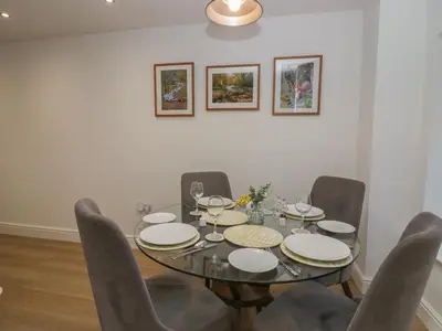 a dining room with a glass table and chairs at Dalegarth Hall Farm Cottage 2 in Holmrook