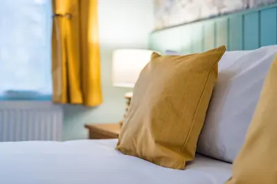 a bed with a brown pillow on it at The Queens in Carlisle