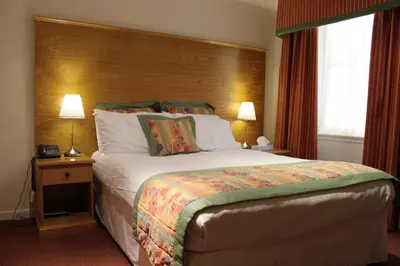 a hotel room with a large bed and two lamps at Horizon Hotel in Ayr