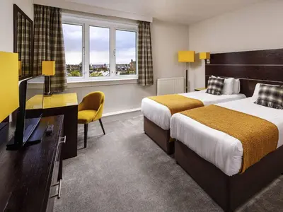 a hotel room with two beds and a television at Mercure Ayr Hotel in Ayr
