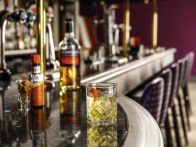 a drink with a gold fish in a glass on a bar at Mercure Ayr Hotel in Ayr