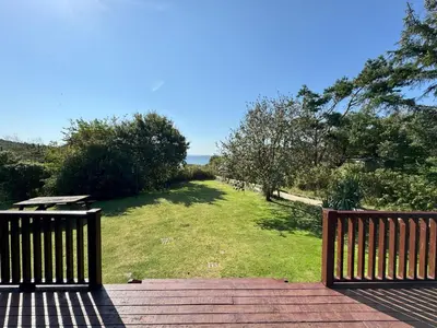 two benches sitting on a deck with a view of the ocean at The Vital Spark in Gatehouse of Fleet