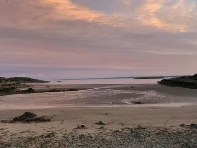 a beach with a cloudy sky and a body of water at The Vital Spark in Gatehouse of Fleet