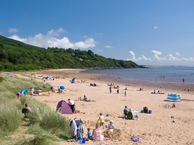 a group of people on a beach near the water at Beautiful Golf and Beach Lodge in Stunning Location - Pass the Keys in Dalbeattie