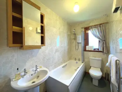 a bathroom with a tub and a sink and a toilet at Beautiful Golf and Beach Lodge in Stunning Location - Pass the Keys in Dalbeattie