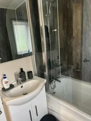a bathroom with a sink and a shower and a tub at Lake District Luxury Lodge in Plumbland