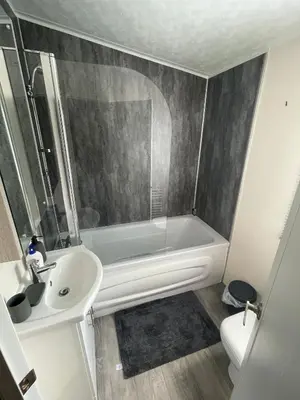 a bathroom with a tub and a sink and a toilet at Lake District Luxury Lodge in Plumbland