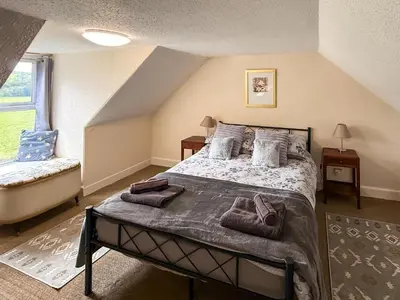 a bedroom with a large bed with pillows on it at Kilpatrick Farm House in Pinmore