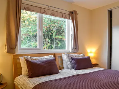 a bedroom with a bed and a window at Swallow Lodge in Carsphairn