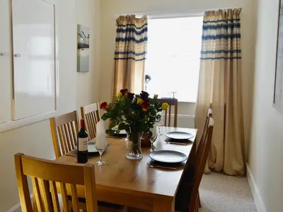 a dining room table with a vase of flowers on it at Burnbank in Kirkgunzeon