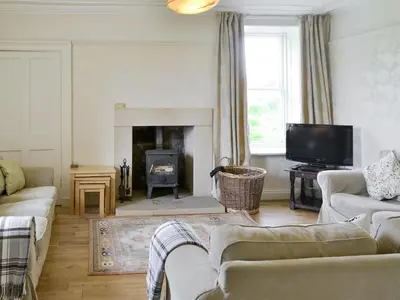 a living room with a couch and a fireplace at Burnfoot Of Cluden in Holywood