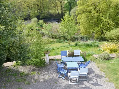 a picnic table and chairs in a garden at Burnfoot Of Cluden in Holywood