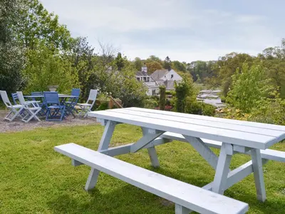 a white picnic table sitting on the grass at Burnfoot Of Cluden in Holywood
