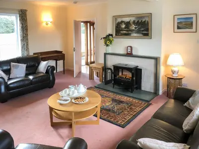 a living room with a couch and a fireplace at Mountain Cross in Gatehouse of Fleet
