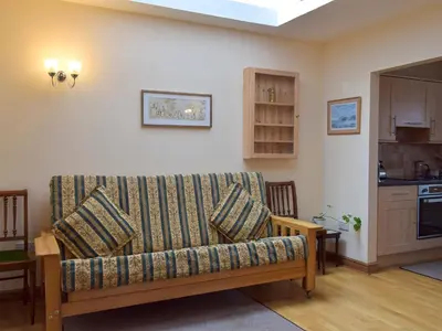 a living room with a couch and a kitchen at Quiet in Whauphill