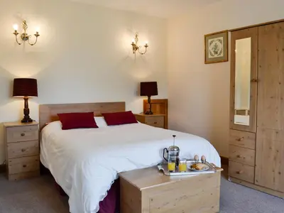 a bedroom with a large white bed with red pillows at Peace in Whauphill