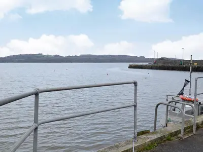 a metal railing next to a body of water at Seaview in Garlieston