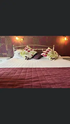 a large bed with pillows on top of it at The White Mare in Beckermet