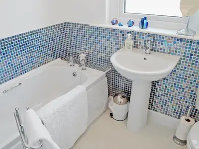 a bathroom with a sink and a bath tub next to a toilet and a sink at Winloma in Port William