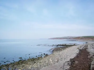 a beach with a rocky shoreline and the ocean at Winloma in Port William