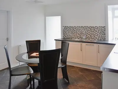 a kitchen with a table and chairs and a sink at Sea-Esta - 28175 in Port William