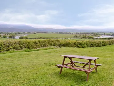 a picnic table sitting on top of a field at The Hen Hoose in Creebridge