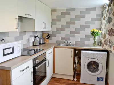 a kitchen with a washer and dryer in it at The Hen Hoose in Creebridge