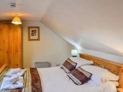 a bedroom with two beds with white sheets and pillows at The Hen Hoose in Creebridge