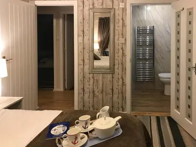 a room with a bed with a tray of tea sets at Driftwood in Mainsriddle
