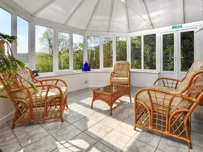 a screened in porch with chairs and windows at Holly Cottage - 28140 in Boreland of Colvend