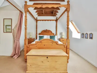 a bedroom with a wooden bed with a wooden trunk at Holly Cottage - 28140 in Boreland of Colvend