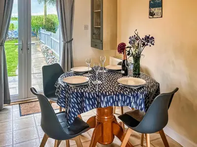 a dining room with a table and chairs at Gigha in Drummore