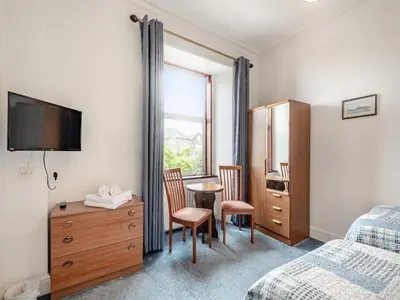 a bedroom with a bed and a desk and a table at Braefield in Portpatrick