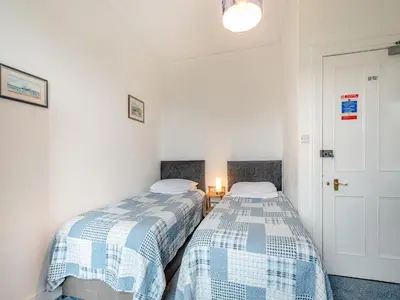 two beds in a room with white walls at Braefield in Portpatrick