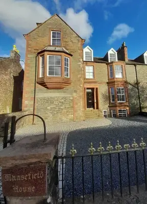 a brick house with a fence in front of it at Kirkcudbright Holiday Apartments - Apartment G in Kirkcudbright