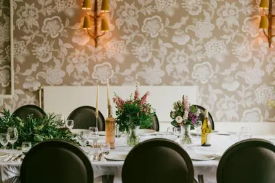 a dining room with a table with chairs and flowers at Marine Troon in Troon
