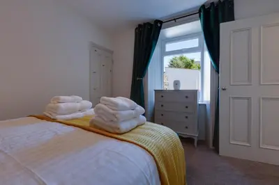 a bedroom with towels stacked on a bed with a window at Westview in Newton Stewart