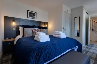 a bedroom with a blue bed with towels on it at Westview in Newton Stewart