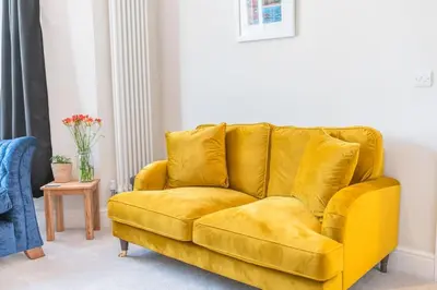 a yellow couch sitting in a living room at Hazelgrove, Ratcliffe Place, Keswick in Keswick
