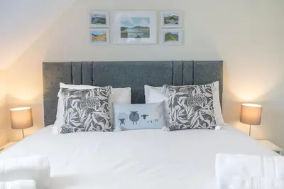 a bedroom with a large white bed with pillows at Hazelgrove, Ratcliffe Place, Keswick in Keswick