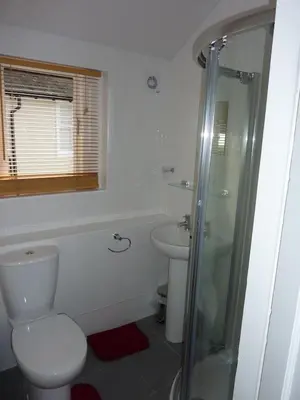 a white bathroom with a toilet and a sink at Oak Lodge in Keswick