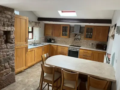 a kitchen with wooden cabinets and a table and chairs at The Cottage in Carlisle