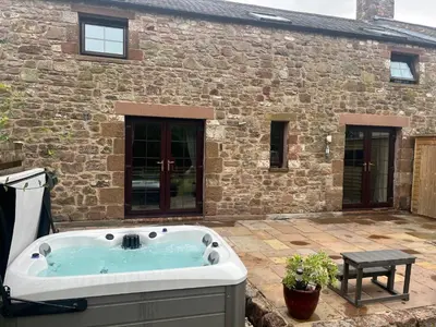 a bath tub in front of a stone building at The Cottage in Carlisle