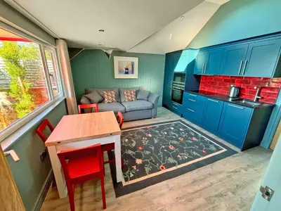 a living room with blue cabinets and a table and a couch at Aird Cottage in Dunure