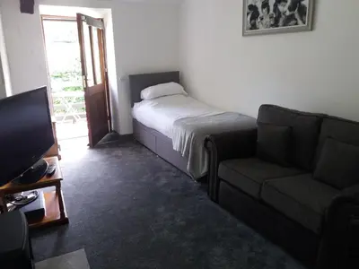 a bedroom with a bed and a couch and a television at NEWFIELD INN in Broughton in Furness