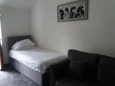 a bedroom with a bed and a couch and a picture at NEWFIELD INN in Broughton in Furness