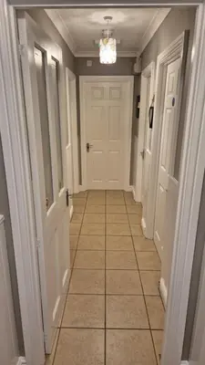 a hallway with a white door and a tiled floor at The Chalets in Eskdale