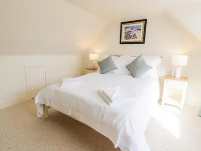 a bedroom with a white bed with two pillows at Saltflats Cottage - Rockcliffe in Dalbeattie